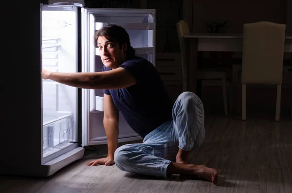 Man breaking diet at night near fridge — Stock Photo, Image