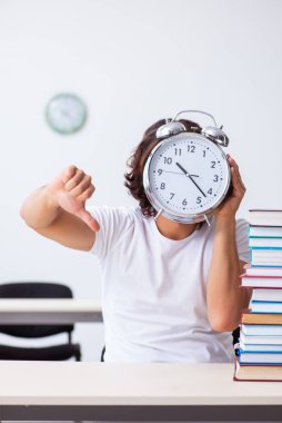 Sınıfta oturan genç erkek öğrenci.