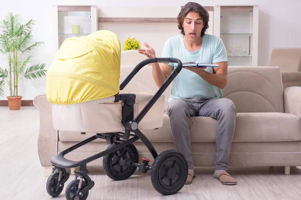 Young man looking after baby in pram — Stock Photo, Image