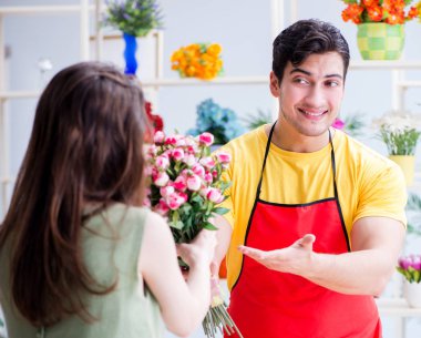 Çiçekçi dükkanında çiçek satıyor.