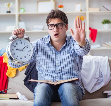 Genç adam dağınık bir odada çalışıyor.