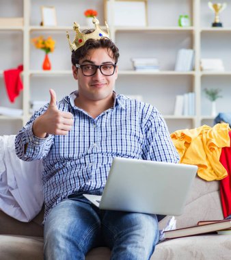 Genç adam dağınık bir odada çalışıyor.