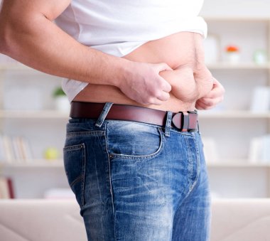 Diyet konseptinde fazladan ağırlık çeken adam.