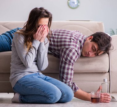 Genç bir aile kavramında içki sorunu yaşayan sarhoş bir koca.