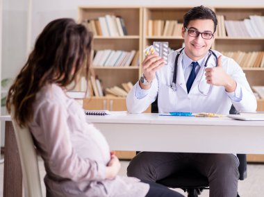 Hamile kadın muayene için doktoru ziyaret ediyor.