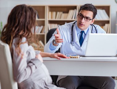 Hamile kadın muayene için doktoru ziyaret ediyor.