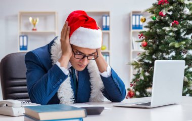 İş adamı Noel tatilini ofiste kutluyor.