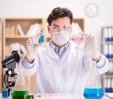 Laboratuvarda virüs aşısı üzerinde çalışan erkek doktor.