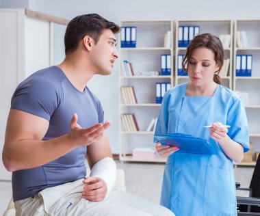 Hastanede yaralanma kontrolü sırasında doktor ve hasta.