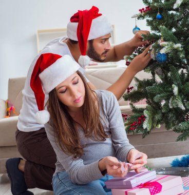 Genç aile Noel 'i kutlayan bir bebek bekliyor.