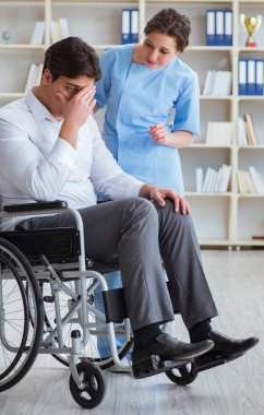 Tekerlekli sandalyedeki hasta düzenli kontrol için doktoru ziyaret ediyor.