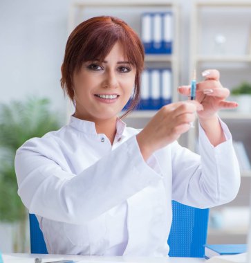 Bir laboratuarda deney yapan kadın bir bilim adamı.