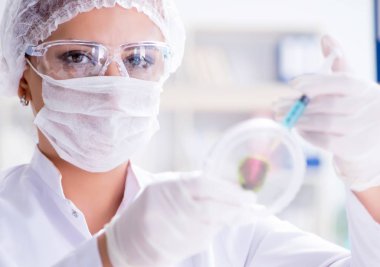 Bir laboratuarda deney yapan kadın bir bilim adamı.