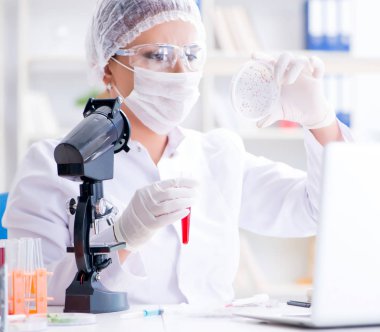 Bir laboratuarda deney yapan kadın bir bilim adamı.