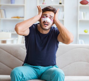 Genç adam estetik cerrahi burnundan sonra evde iyileşiyor.