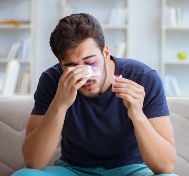 Genç adam estetik cerrahi burnundan sonra evde iyileşiyor.