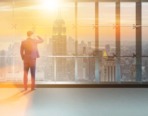 Businessman in front of office window thinking of new challenges