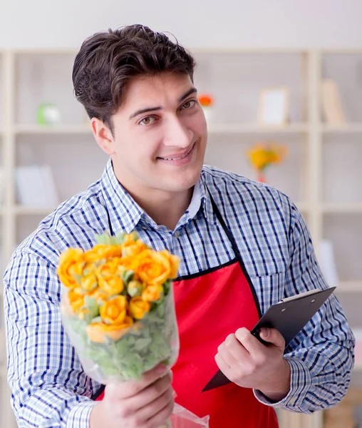 Asistente de floristería ofreciendo un ramo de flores — Foto de Stock