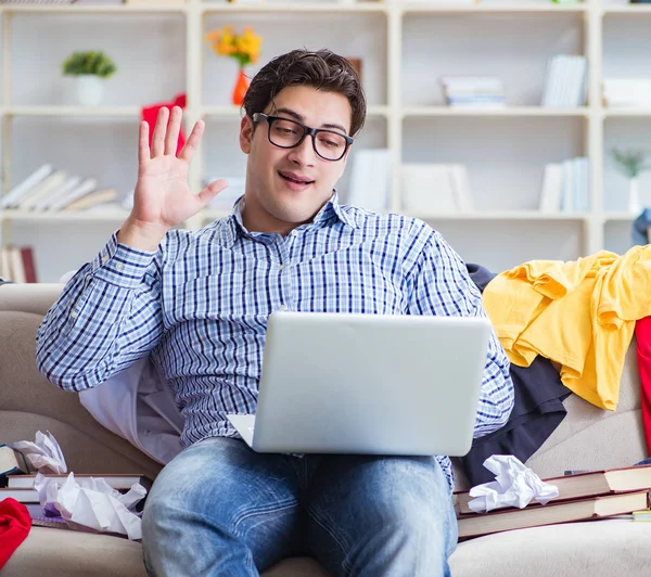 Genç adam dağınık bir odada çalışıyor.