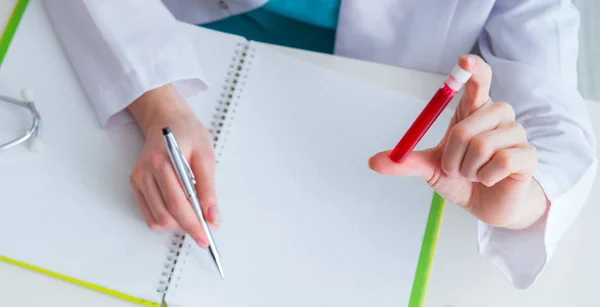 Médico estudiando tubo de sangre en concepto médico —  Fotos de Stock