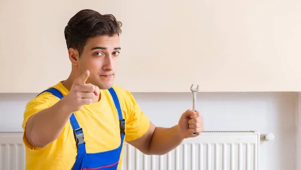 Jovem reparador contratante reparação painel de aquecimento — Fotografia de Stock