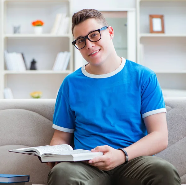 Νεαρός φοιτητής που προετοιμάζεται για τις εξετάσεις που σπουδάζουν στο σπίτι σε καναπέ — Φωτογραφία Αρχείου
