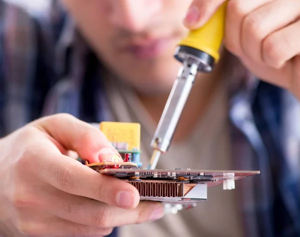 Professional repairman repairing computer in workshop