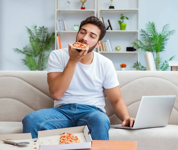 Чоловік їсть піцу, маючи винос вдома розслабляючий відпочинок — стокове фото