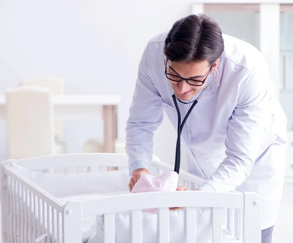 Man mannelijke kinderarts in de buurt van babybed voor te bereiden om te onderzoeken — Stockfoto