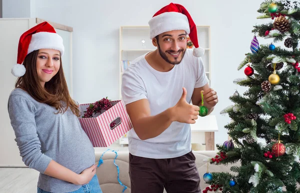 クリスマスを祝う子供の赤ちゃんを期待している若い家族 — ストック写真