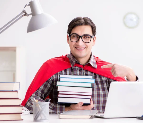 Estudiante súper héroe con una computadora portátil estudiando preparación para los exámenes —  Fotos de Stock