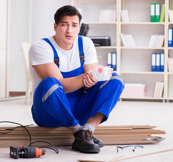 Mladý pracovník pracující na podlahové laminátové dlaždice — Stock fotografie