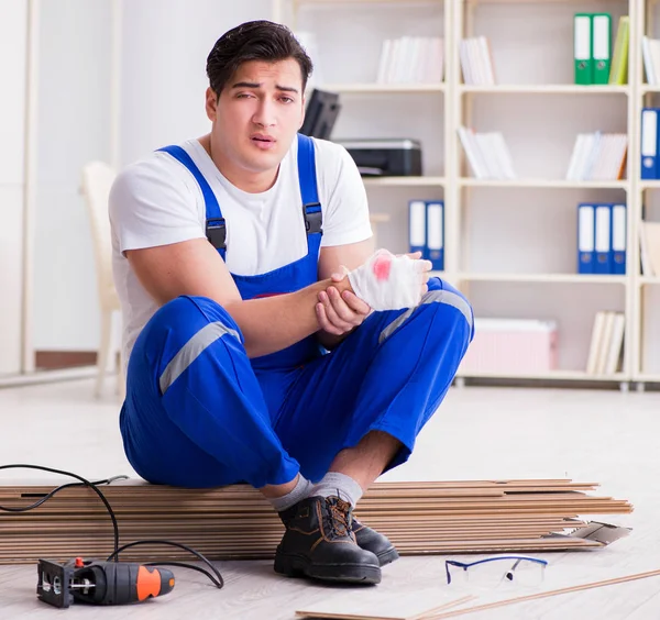 Giovane lavoratore che lavora su pavimenti in laminato — Foto Stock