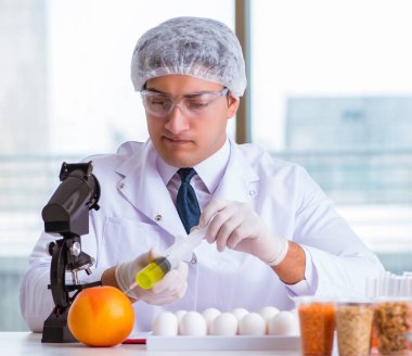 Besin uzmanı gıda ürünlerini laboratuarda test ediyor.