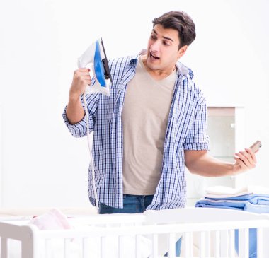 Genç baba yeni doğan bebeğe bakıyor.