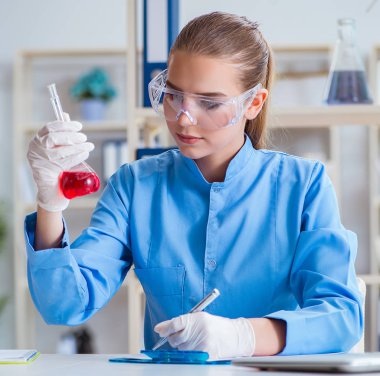 Bir laboratuarda deney yapan kadın bir bilim adamı.