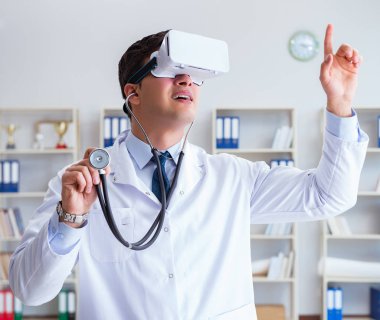 Sanal gerçeklik kulaklığı olan genç doktor ofiste çalışıyor.