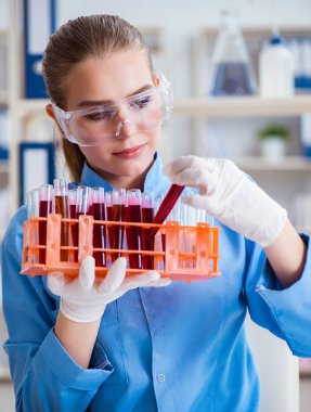 Bir laboratuarda deney yapan kadın bir bilim adamı.