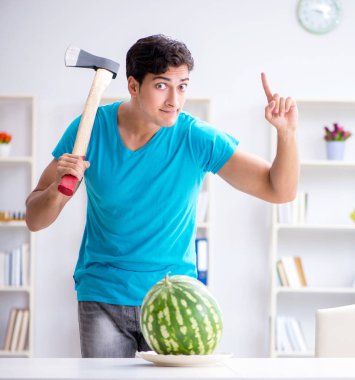 Evde karpuz yiyen bir adam.