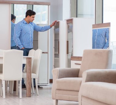 Genç adam mobilya dükkanından alışveriş yapıyor.