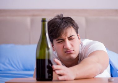 Yatakta içen alkolik adam depresyona giriyor.