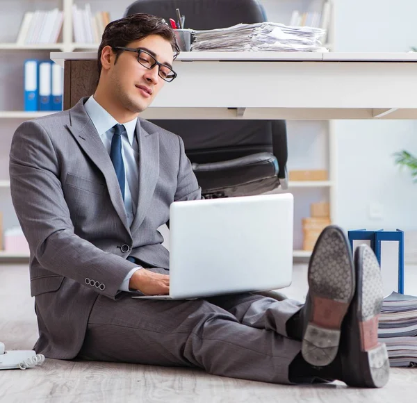 Geschäftsmann arbeitet und sitzt auf dem Fußboden im Büro — Stockfoto