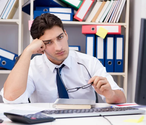 Empresario trabajando en la oficina con montones de libros y papeles —  Fotos de Stock