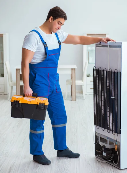 Repairman contractor repairing fridge in DIY concept