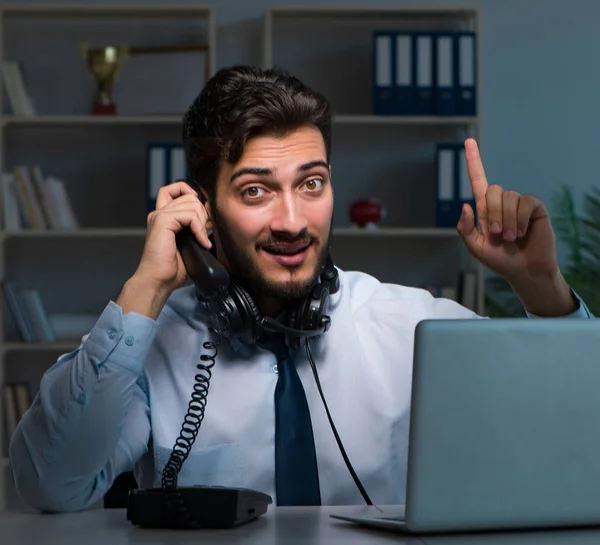 Ung man i call center koncept som arbetar sent övertid på kontoret — Stockfoto