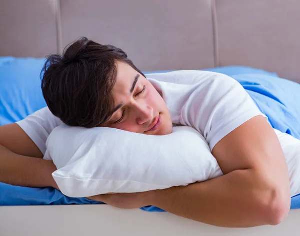 Uykusuzluk çeken bir adam yatakta yatıyor. — Stok fotoğraf