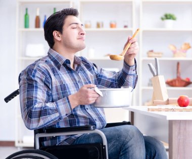 Engelli adam mutfakta çorba hazırlıyor.