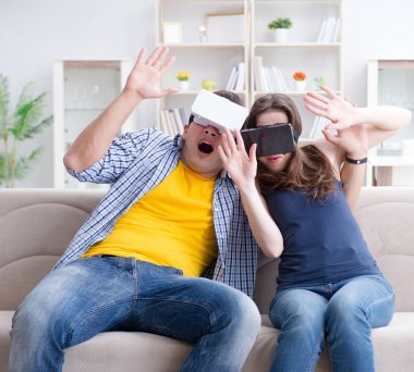 Genç bir aile sanal gerçeklik gözlükleriyle oyun oynuyor.