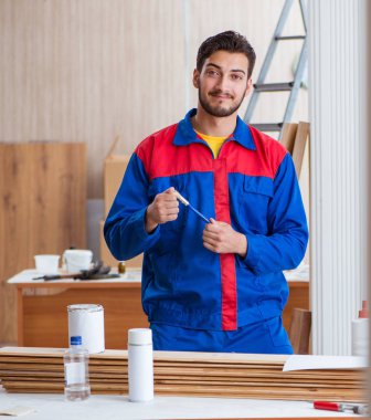 Yooung marangoz boyayla uğraşıyor.