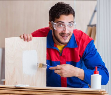 Yooung marangoz boyayla uğraşıyor.